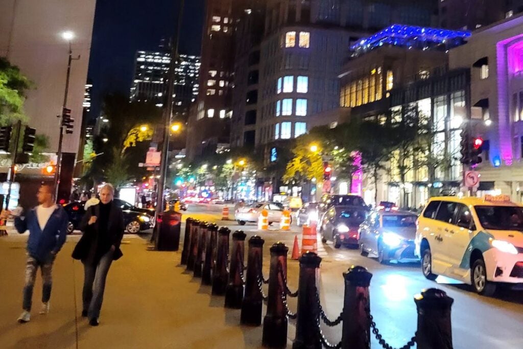 Nighttime street scene in downtown Chicago with city lights, traffic, and pedestrians along the Magnificent Mile