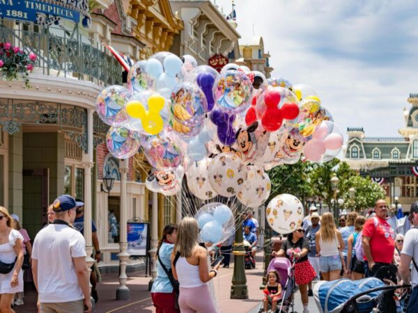 Disney character balloons for sale on Main Street USA at Magic Kingdom Walt Disney World with crowds of families