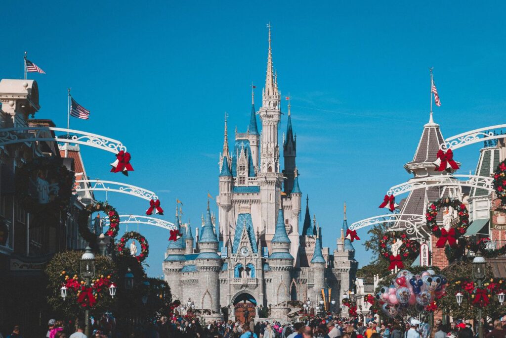 Cinderella Castle viewed from Main Street USA at Magic Kingdom Walt Disney World decorated for Christmas with holiday wreaths and crowds