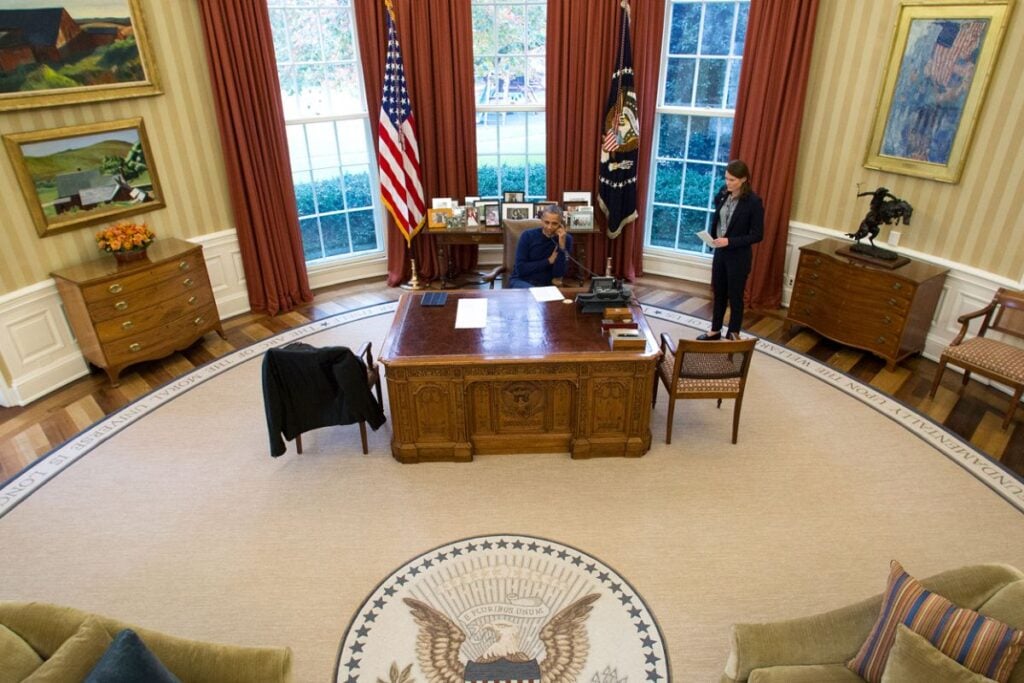 President Barack Obama on a phone call at the Resolute Desk in the Oval Office of the White House
