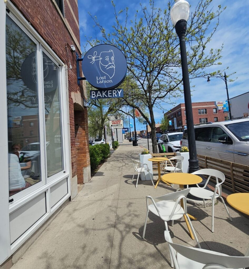 Lost Larson bakery sign and sidewalk café tables on Clark Street in Andersonville, Chicago