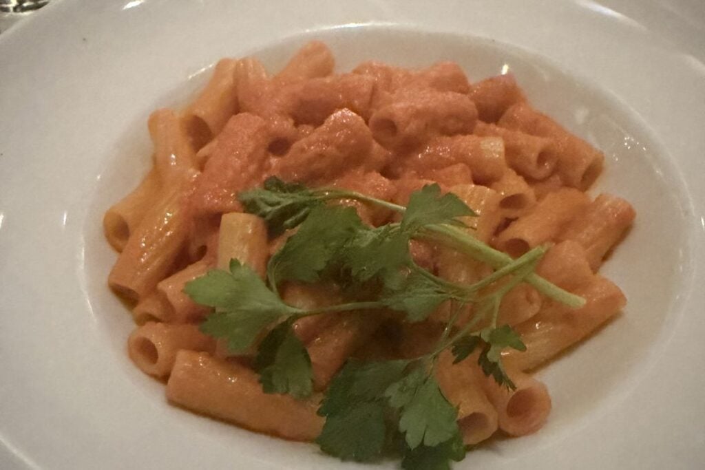Bowl of rigatoni in creamy vodka sauce garnished with parsley at Carmine's in Chicago