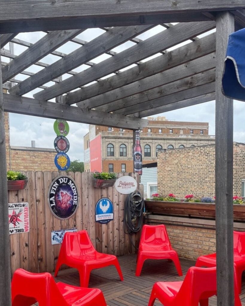 Gene's Sausage Shop rooftop beer garden in Lincoln Square Chicago with wooden pergola, red chairs, and craft beer signs