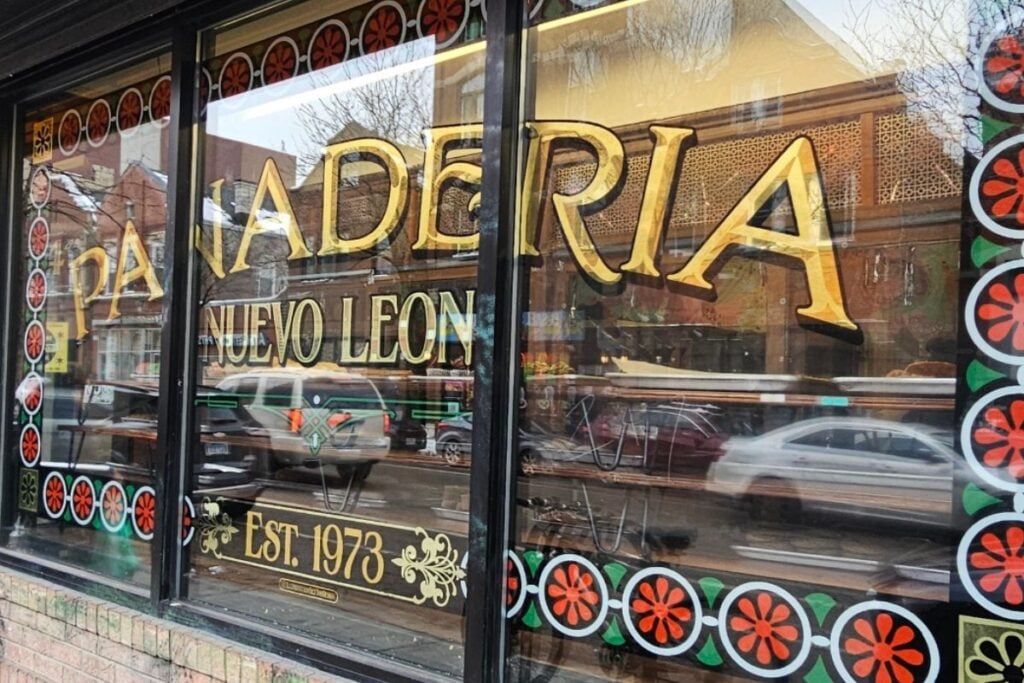 Gold lettered window of Panadería Nuevo León, a Mexican bakery established 1973 in Pilsen, Chicago