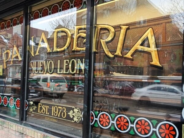 Gold lettered window of Panadería Nuevo León, a Mexican bakery established 1973 in Pilsen, Chicago