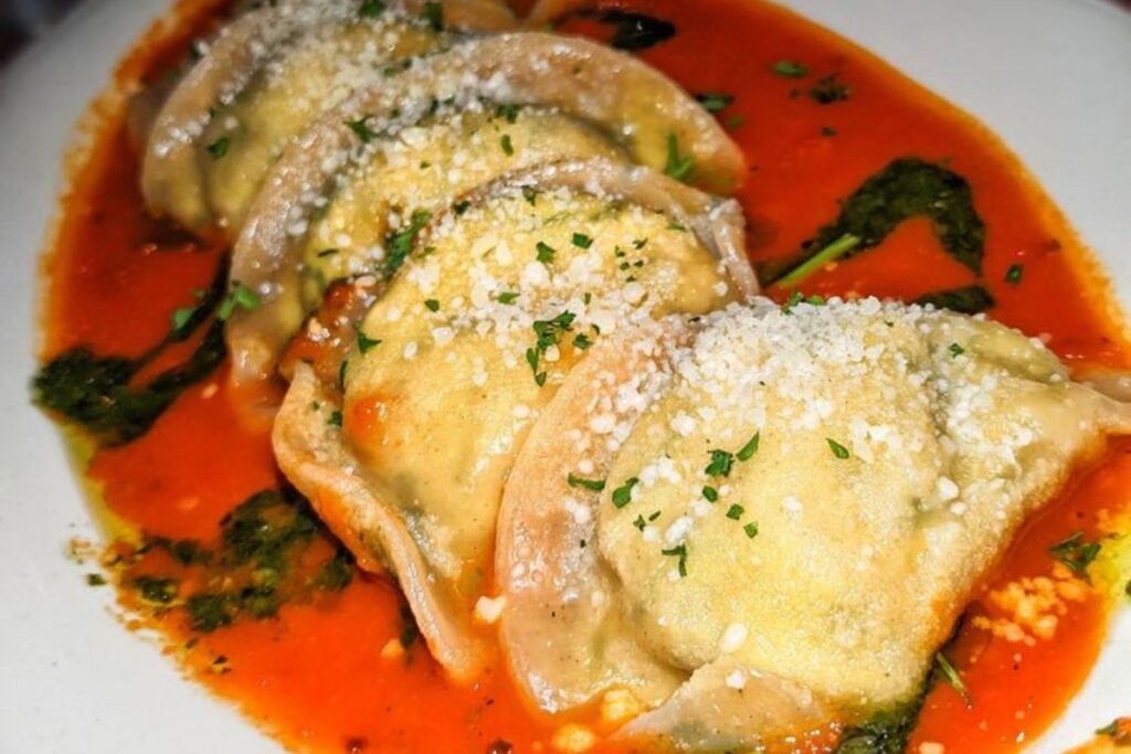 Ravioli in marinara with pesto drizzle and grated Parmesan at The Village restaurant in Chicago's Loop