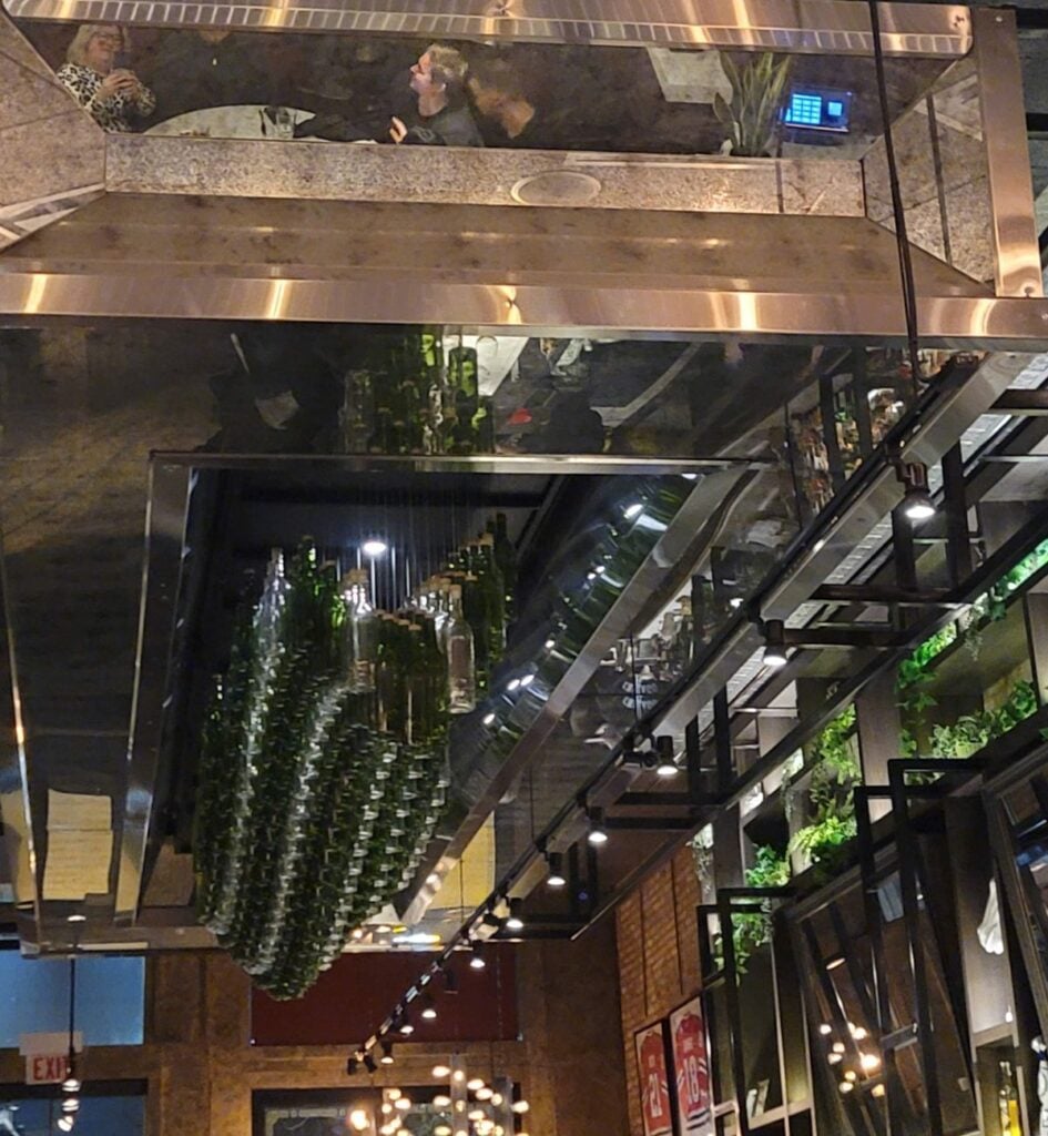 Mirrored ceiling and hanging wine bottle display inside Viaggio Italian restaurant in Chicago's West Loop