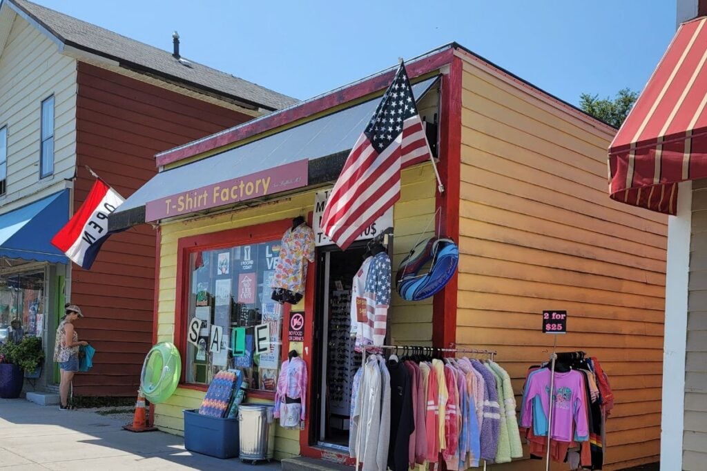 T-Shirt Factory storefront with beach gear and clothing racks on a street in downtown New Buffalo, Michigan